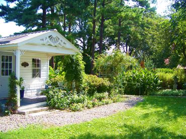 Sunny backyard garden with a small white house.