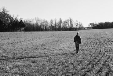 Person walking alone in a field.