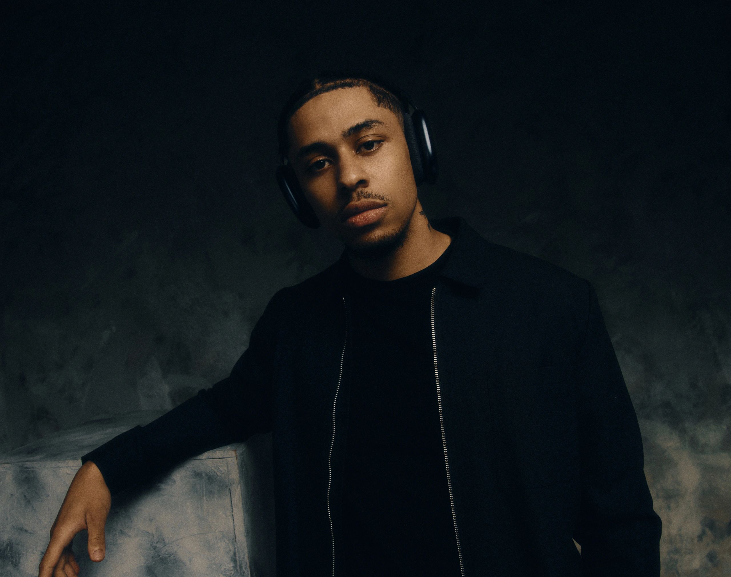 Young man with headphones in a dark moody setting.