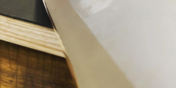 Close-up of a glossy white surface on a wooden table.