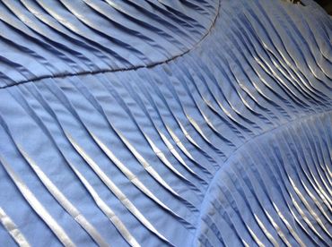 Pale blue and silver textile artwork with applique, pleating, tucking and machine stitching.