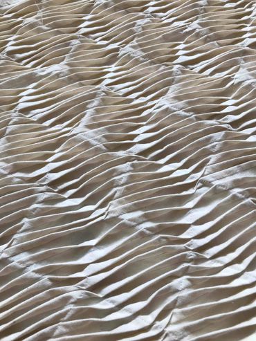 Pleated fabric resembling ripples in sand.