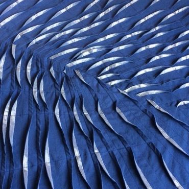 Blue and silver pleated and tucked fabric artwork.