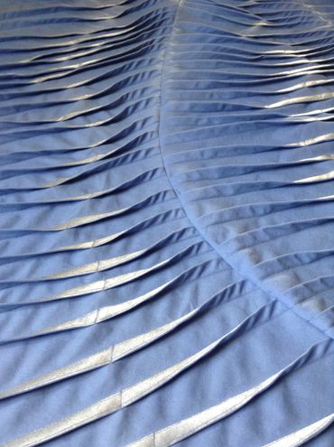 Pale blue and silver pleated and tucked textile artwork in detail image.