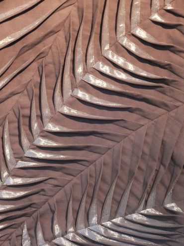 Detail image of brown pleated & tucked fabric with applique and machine stitched textile artwork.
