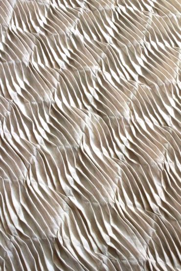 Pleated and tucked textiles in cream fabric inspired by sand ripples.