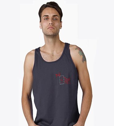 Man wearing a dark tank top with a tattoo on his left arm.