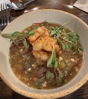 Shrimp soup with greens in a bowl.