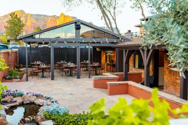 Cozy outdoor patio with dining tables and string lights.