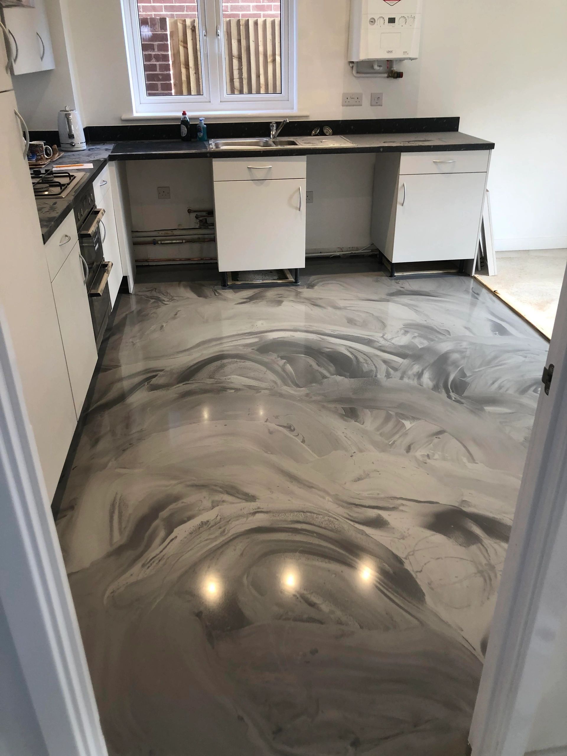 Kitchen with glossy marbled epoxy floor.