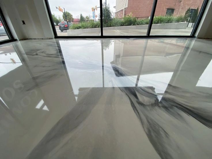 Polished, reflective marble-like floor inside a room with large windows.