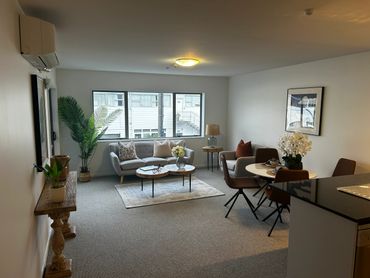 Cozy living room with modern furniture, plants, and soft lighting.