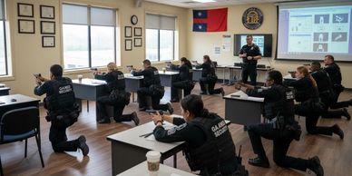 Security personnel practicing firearm training in a classroom setting.