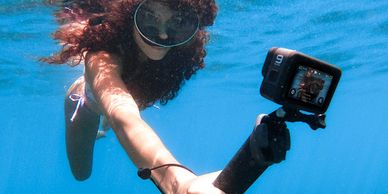Swimmer underwater using a GoPro and hand mount