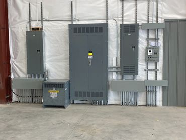 Electrical control panels with conduit pipes inside an industrial building.