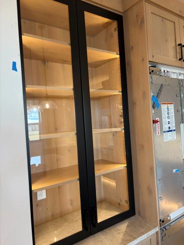 Wooden cabinet with glass doors and shelves.