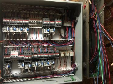 An open electrical control panel with organized wiring and components.