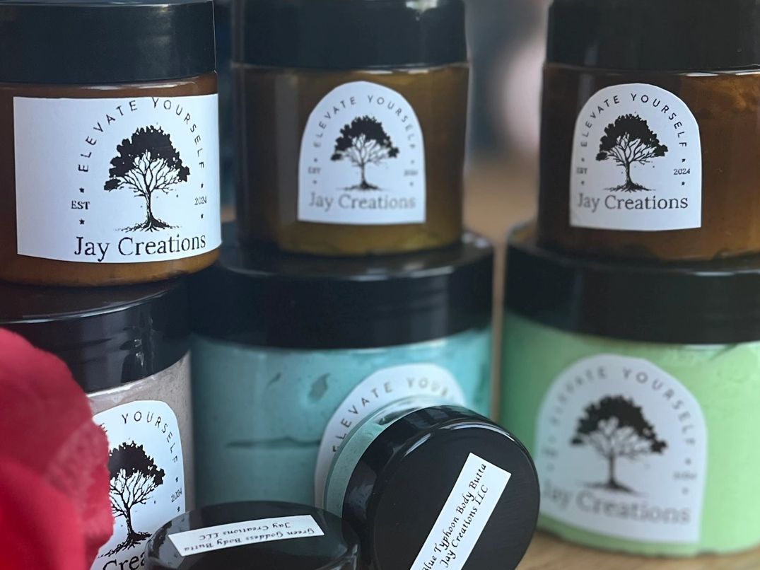 Jars of Jay Creations body butter with black lids and white labels.
