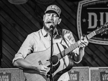 Austin Hamilton playing on stage with a guitar