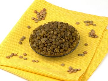 Bowl of green lentils on yellow cloth