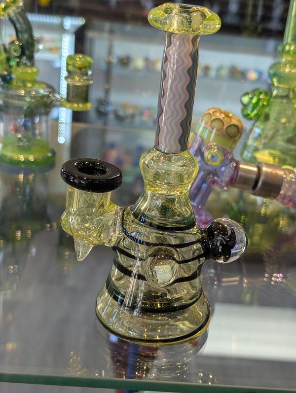 Small glass water pipe with black accents and intricate patterns.