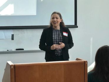 Woman giving a presentation in a classroom or meeting room.