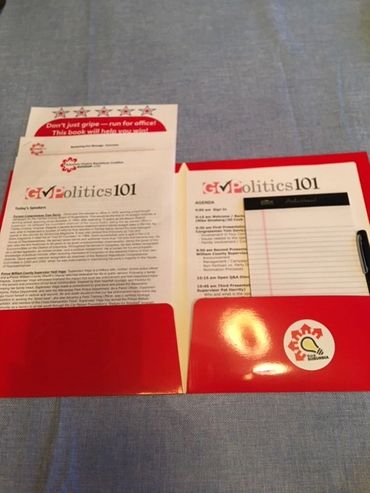 A red folder containing political education materials and a notepad.