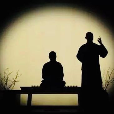 Silhouettes of two people against a large circular light.