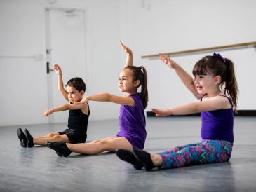 Children in dance class practicing arm movements.