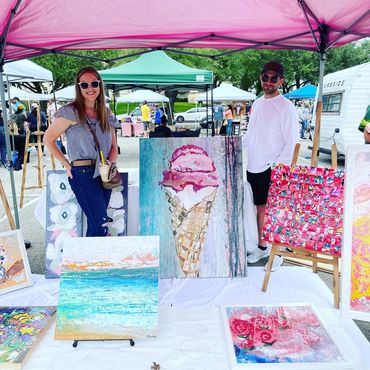 Artworks on display under a pink tent