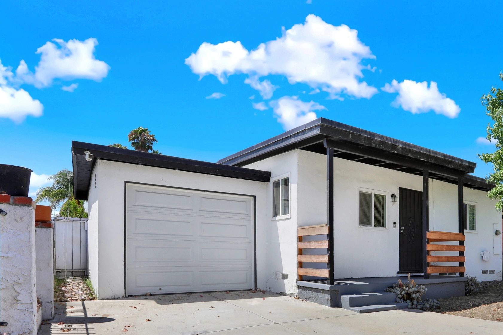 Modern white house with black accents and a two-car garage.