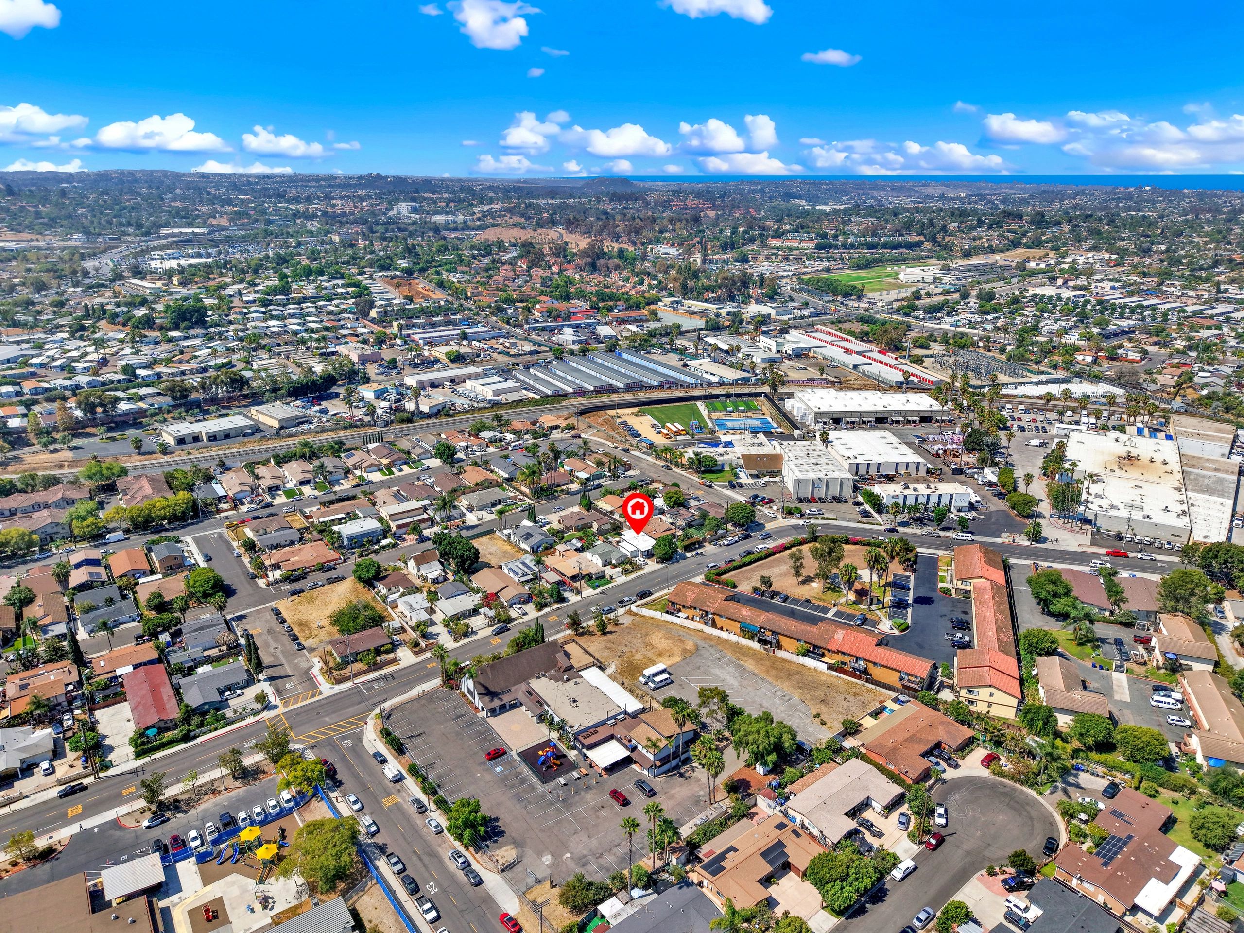 Aerial view of a suburban neighborhood under a clear blue sky.