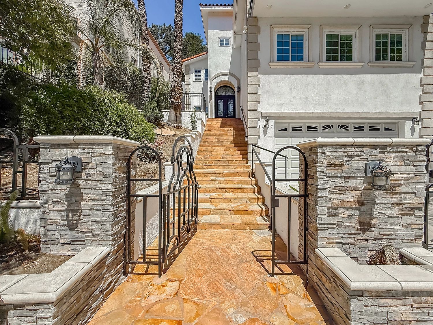 Entrance with stone stairs and wrought iron gate.
