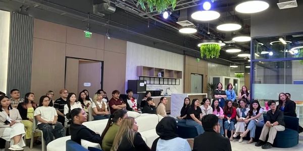 Group of people attentively watching a presentation in an office.