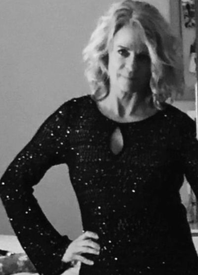 Image of Melanie Kross in a black dress from waste up.