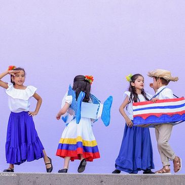 Young students in Venezuelan folk dance costumes performing at a Dulce Tricolor cultural event in th