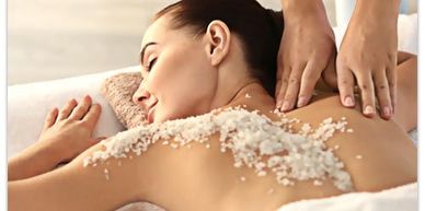Woman receiving a relaxing salt scrub massage on her back.