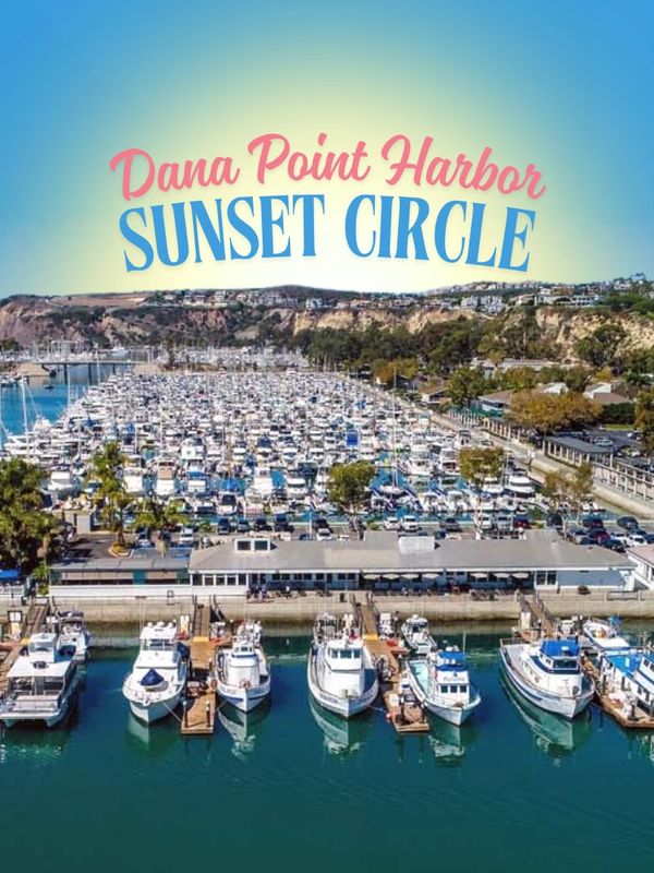 Dana Point Harbor marina filled with boats under clear blue sky.