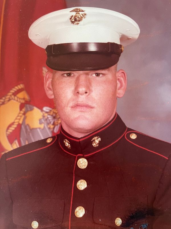 Portrait of a young Marine in full dress uniform with a serious expression.