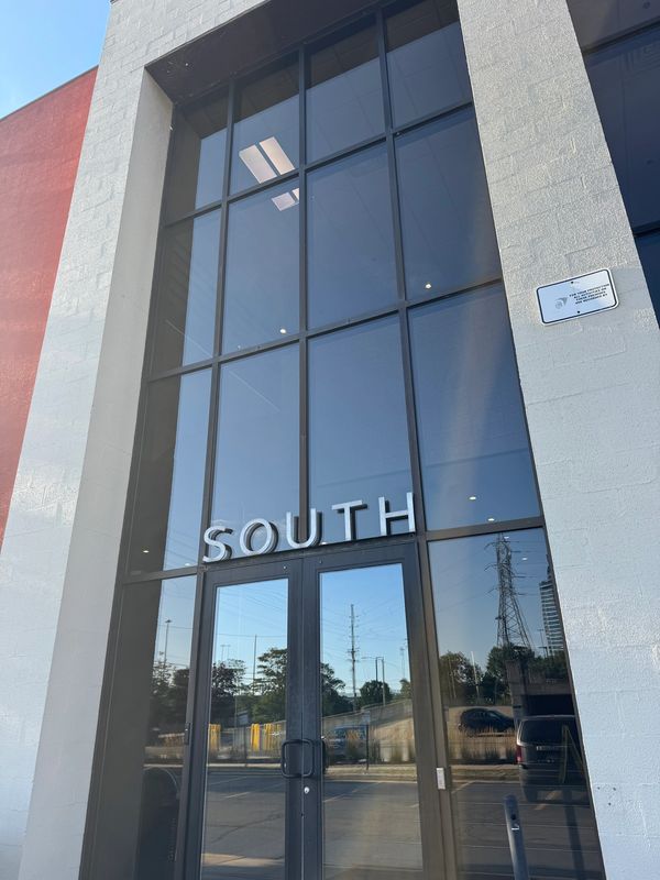 Glass entrance door with "SOUTH" sign above it on a building.