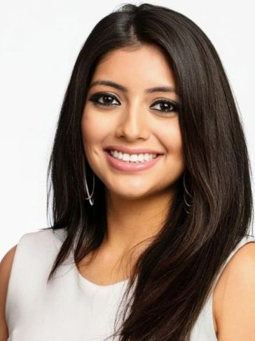 Smiling woman with long dark hair and hoop earrings.