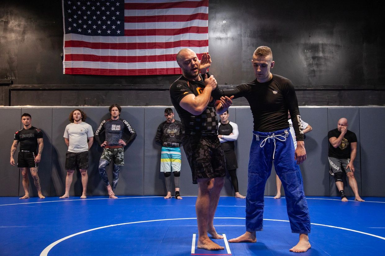 Instructor Zach Rockwell shows a jiu jitsu move in front of a class in omaha nebraska at kaizen