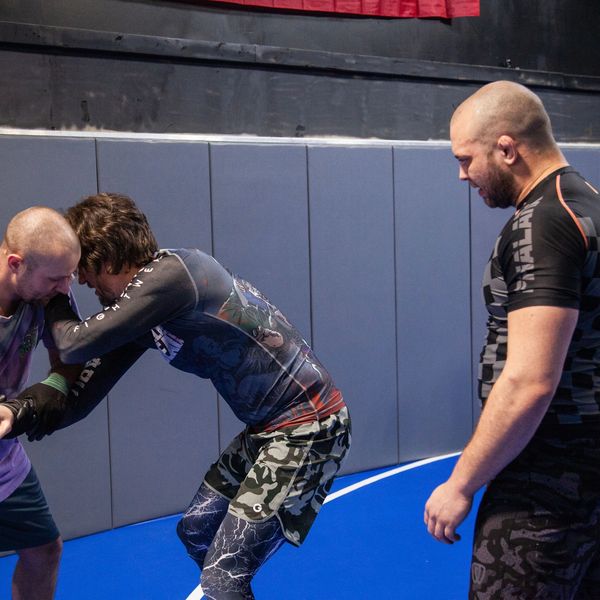 Jiu Jitsu instructor zack rockwell in omaha nebraska looks at students practicing jiujitsu