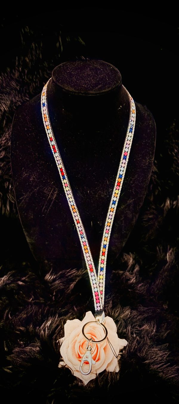 Colorful beaded lanyard with keyring displayed on a black stand.