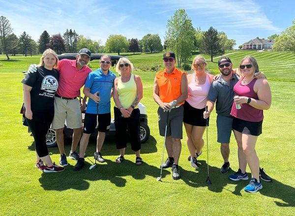 Guys and girls posing with golf clubs