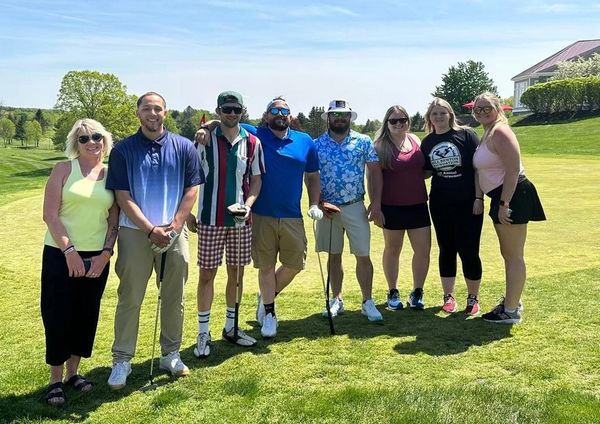 Bill Benton's family posing with golfers