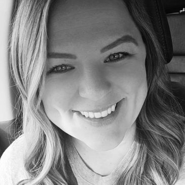 Black and white close-up smiling portrait of a woman.