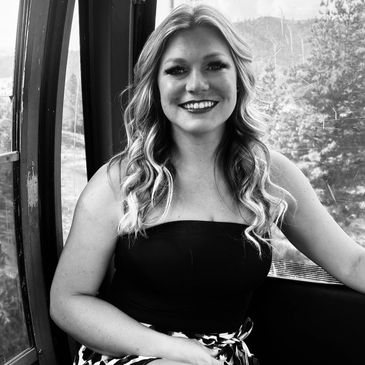 Smiling woman with wavy hair inside a cable car.