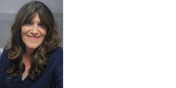 Smiling woman with long curly brown hair wearing a navy blue top.