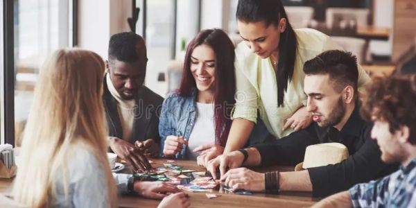 A diverse group of friends enjoying a board game together at a table.